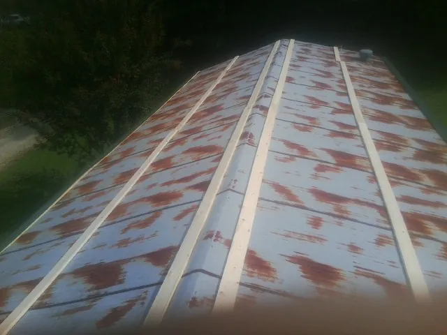 Rusted metal roof panels with new wood purlins before replacement — Storm Damage Roof Repair in Fiskeville by Roofing Brothers