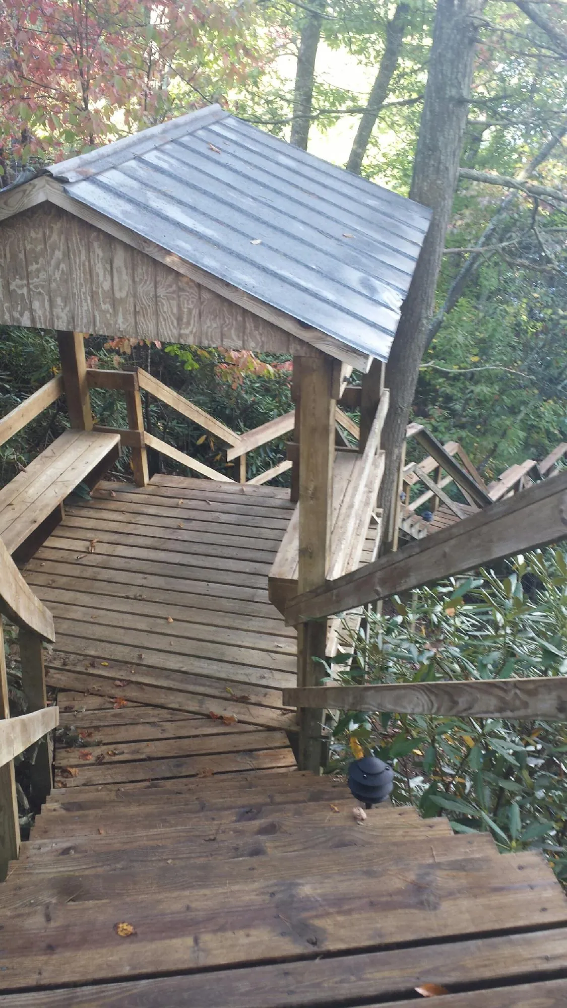 Metal roofed shelter over wooden steps on a wooded walkway — Skylight Repair & Installation work by our crew in Fiskeville