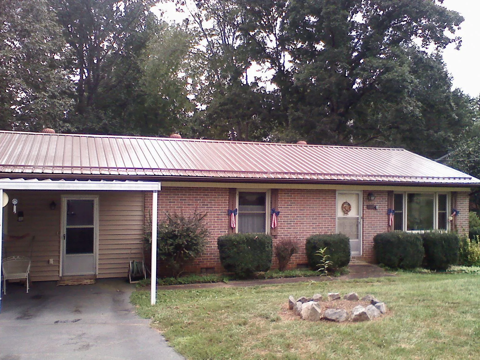 Bronze metal roof and carport on a brick ranch home — Roof Repair work by our crew in Fiskeville